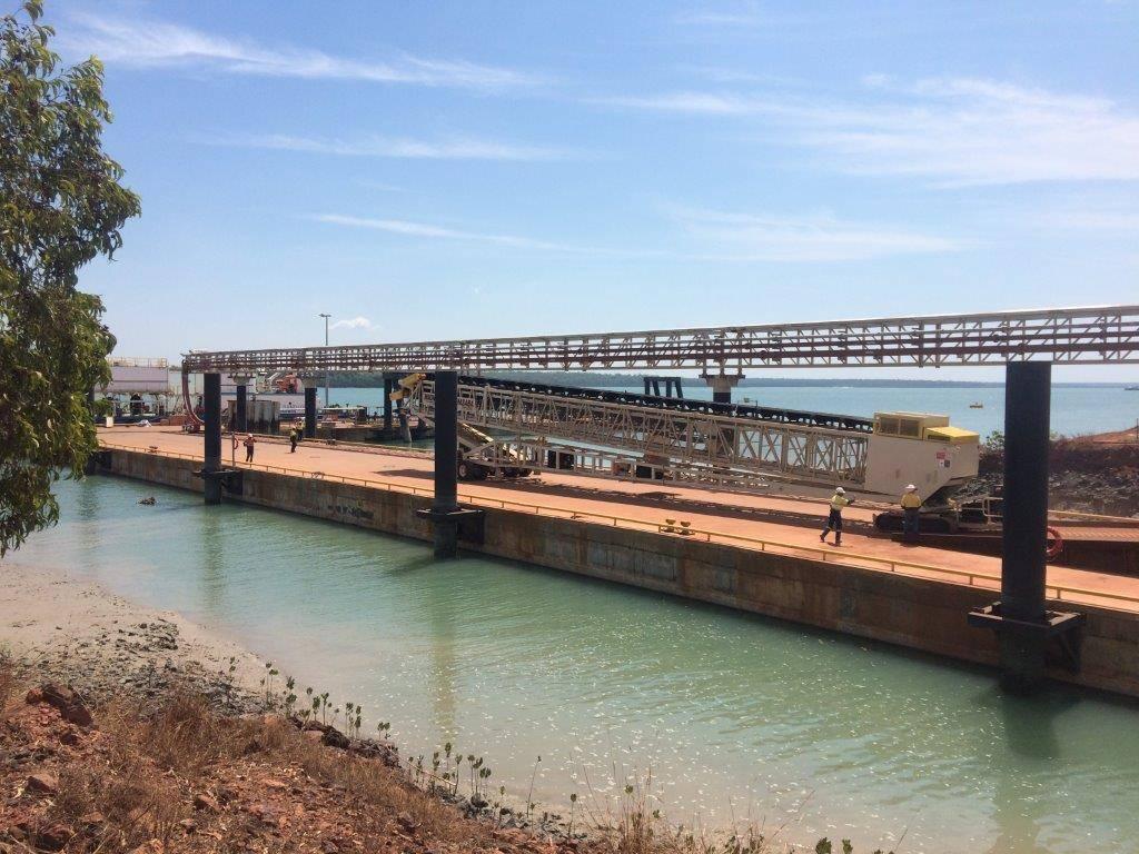 Wharf infrastructure on the Tiwi Islands with equipment and workers supporting marine operations